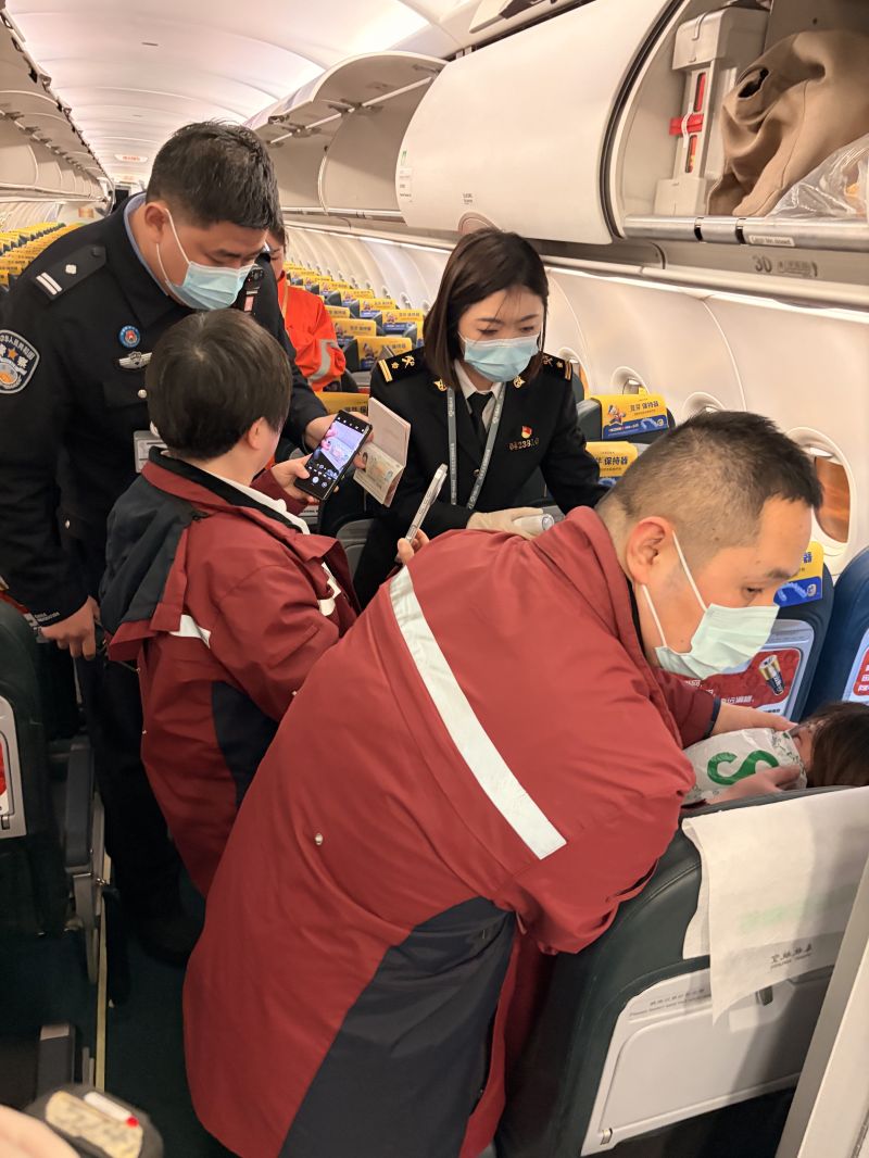 石家庄机场海关旅检一科关员李知仪在入境航班客舱中与边检、急救工作人员联合救治急症旅客。樊权辉摄